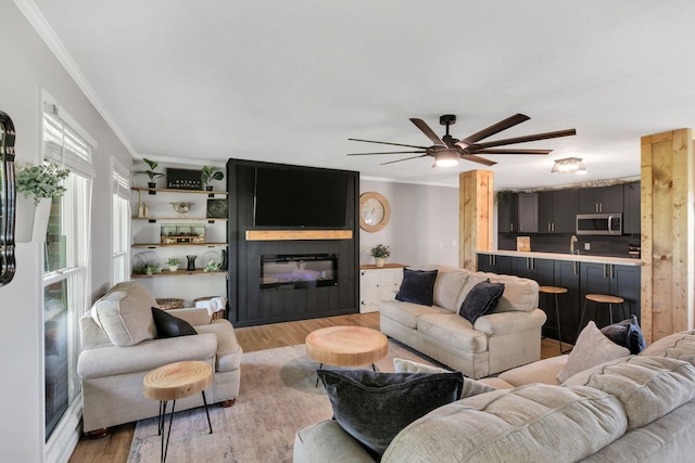 1800 Old Highway 52, Lafayette, TN 37083 - living room featuring crown molding, a fireplace, light wood-style flooring, and a ceiling fan