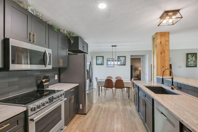 1800 Old Highway 52, Lafayette, TN 37083 - kitchen with stainless steel appliances, a sink, tasteful backsplash, light stone counters, and light wood-style flooring