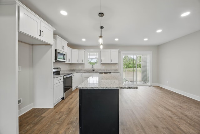 1917 Lewter Dr, Clarksville, TN 37042 - kitchen with appliances with stainless steel finishes, a sink, baseboards, a center island, and white cabinets