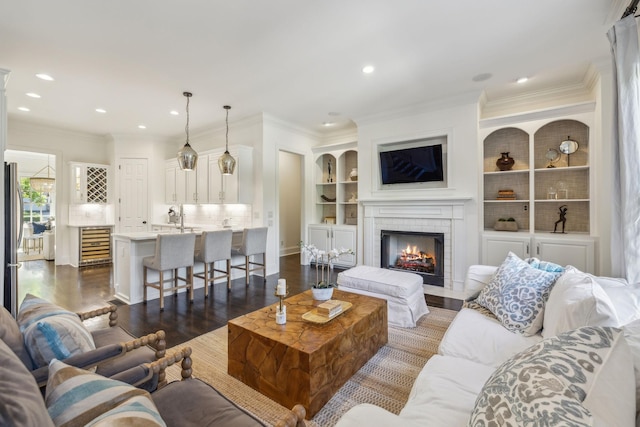 424 Wild Elm St, Franklin, TN 37064 - living room with dark wood-style flooring, a fireplace, built in shelves, recessed lighting, and ornamental molding
