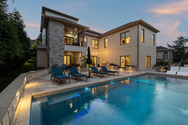 424 Wild Elm St, Franklin, TN 37064 - back of property at dusk featuring a balcony, a patio area, an outdoor pool, and a ceiling fan
