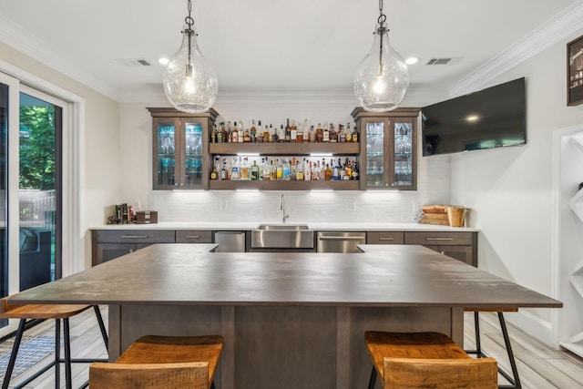 424 Wild Elm St, Franklin, TN 37064 - indoor wet bar featuring stainless steel dishwasher, pendant lighting, decorative backsplash, and ornamental molding