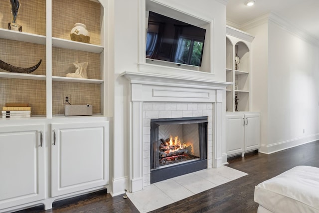 424 Wild Elm St, Franklin, TN 37064 - living room featuring ornamental molding, dark wood-style floors, a tiled fireplace, baseboards, and built in shelves