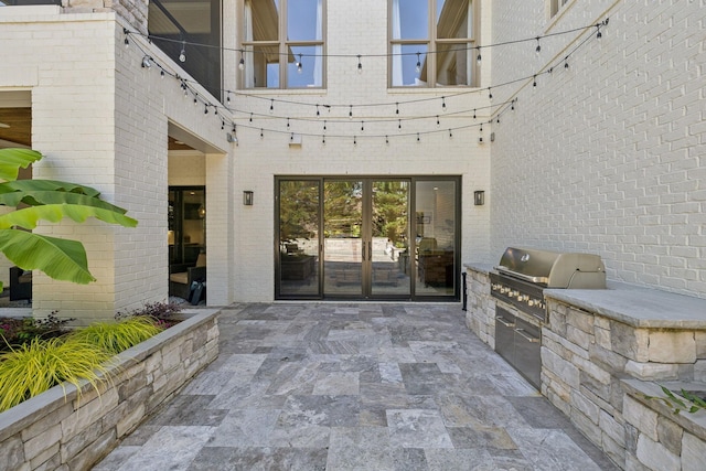 424 Wild Elm St, Franklin, TN 37064 - view of exterior entry with exterior kitchen, a patio, and brick siding