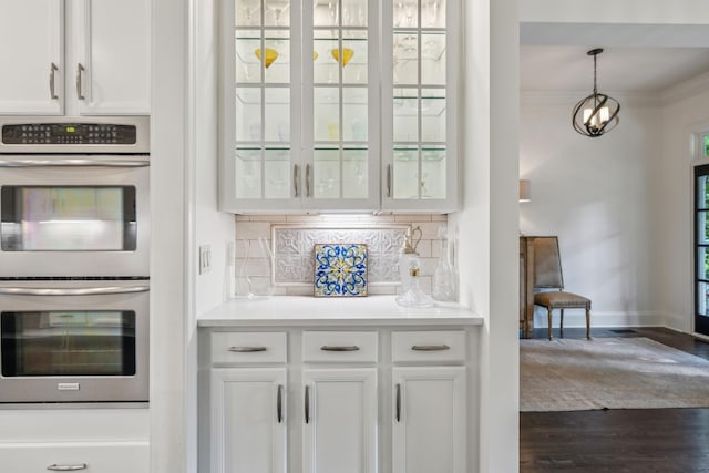424 Wild Elm St, Franklin, TN 37064 - kitchen with stainless steel double oven, backsplash, white cabinetry, and ornamental molding