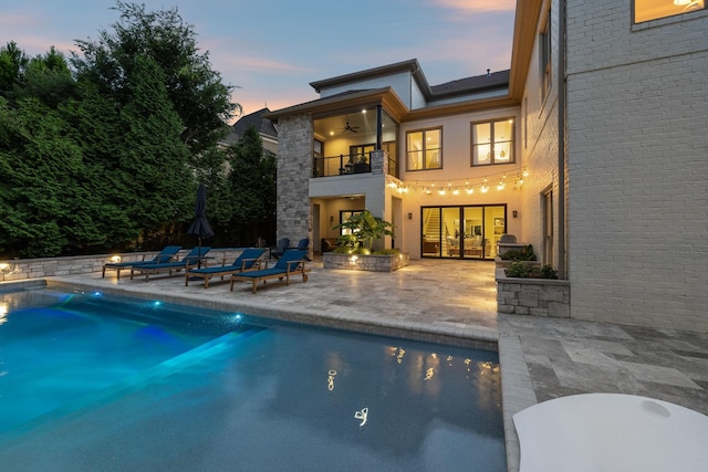 424 Wild Elm St, Franklin, TN 37064 - back of property at dusk featuring a balcony, a patio area, ceiling fan, and an outdoor pool