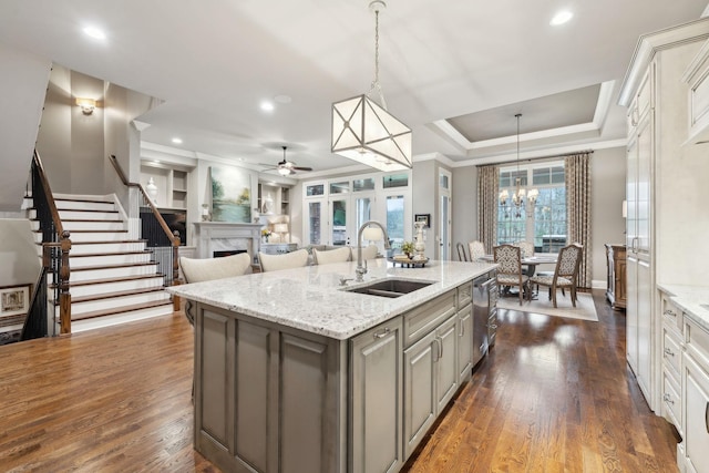 8704 Wolfsbane Ln, College Grove, TN 37046 - kitchen featuring a fireplace, gray cabinetry, crown molding, a ceiling fan, and a center island with sink
