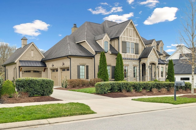 8704 Wolfsbane Ln, College Grove, TN 37046 - view of front of property with an attached garage, a standing seam roof, roof with shingles, a chimney, and concrete driveway