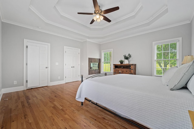 1417 Guill Rd, Mount Juliet, TN 37122 - bedroom with a tray ceiling, multiple windows, crown molding, wood finished floors, and ceiling fan