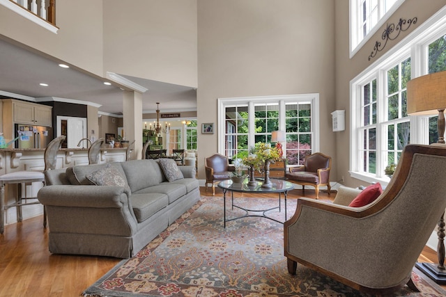 3285 Blazer Rd, Franklin, TN 37064 - living area featuring a chandelier, a high ceiling, wood finished floors, plenty of natural light, and crown molding