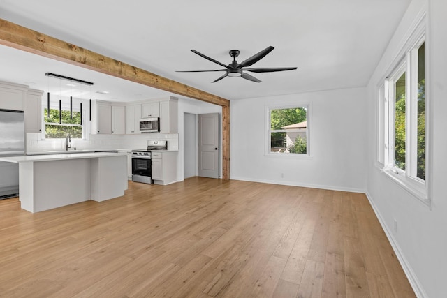 104 Dolphus Dr, Hendersonville, TN 37075 - unfurnished living room with plenty of natural light, ceiling fan, light wood-style floors, baseboards, and beamed ceiling