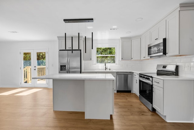 104 Dolphus Dr, Hendersonville, TN 37075 - kitchen with stainless steel appliances, a sink, decorative backsplash, light wood-style flooring, and a kitchen island