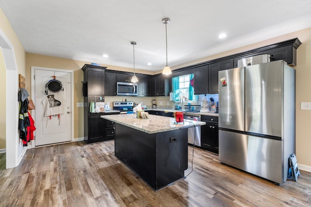 1710 Collins Hollow Rd, Lewisburg, TN 37091 - kitchen with appliances with stainless steel finishes, a center island, light wood finished floors, dark cabinetry, and recessed lighting