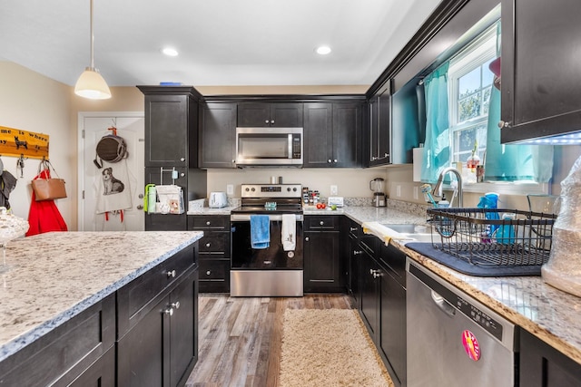 1710 Collins Hollow Rd, Lewisburg, TN 37091 - kitchen featuring stainless steel appliances, light wood-type flooring, a sink, light stone counters, and hanging light fixtures