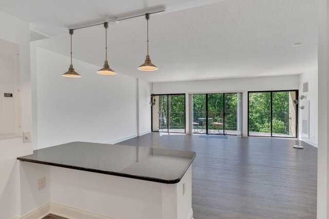 6666 Brookmont Ter Unit 307, Nashville, TN 37205 - kitchen featuring open floor plan, wood finished floors, dark countertops, decorative light fixtures, and baseboards