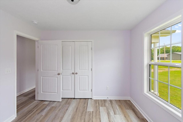 1161 Honey Ln, Estill Springs, TN 37330 - unfurnished bedroom featuring multiple windows, light wood-style floors, and a closet