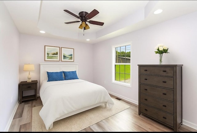 1161 Honey Ln, Estill Springs, TN 37330 - bedroom featuring light wood-type flooring, recessed lighting, a tray ceiling, and ceiling fan