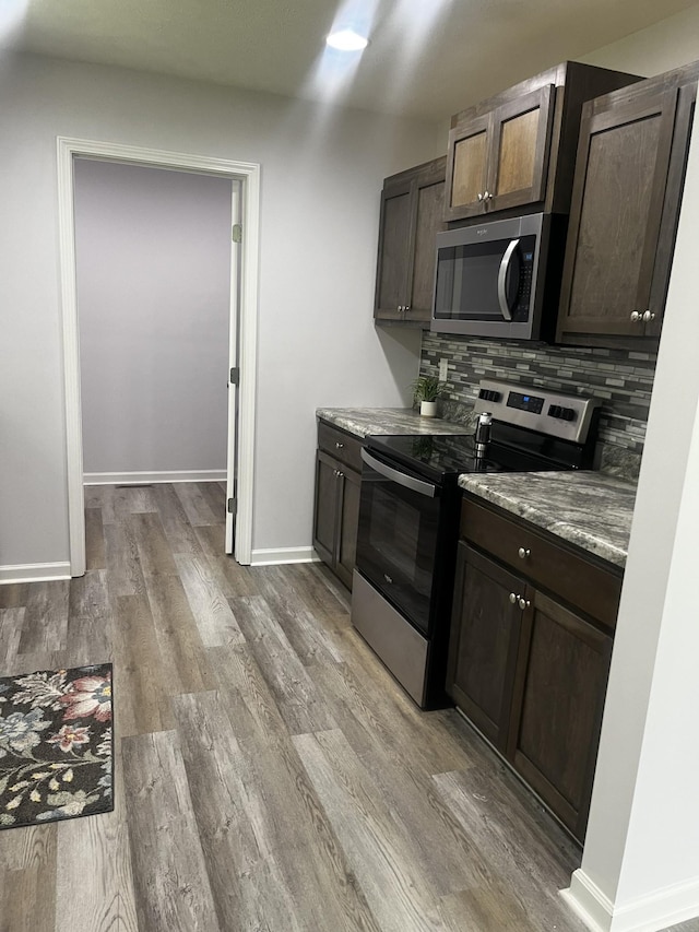 1161 Honey Ln, Estill Springs, TN 37330 - kitchen with appliances with stainless steel finishes, dark brown cabinets, light wood-style floors, and tasteful backsplash