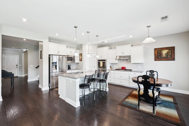 633 Fall Creek Cir, Goodlettsville, TN 37072 - kitchen featuring appliances with stainless steel finishes, under cabinet range hood, a sink, a center island with sink, and decorative light fixtures