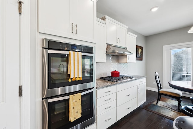 633 Fall Creek Cir, Goodlettsville, TN 37072 - kitchen with under cabinet range hood, appliances with stainless steel finishes, baseboards, backsplash, and dark wood-style floors