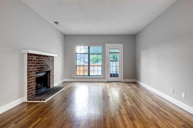 504 Macfie Ct, Madison, TN 37115 - unfurnished living room with wood finished floors, a fireplace, a textured ceiling, and baseboards