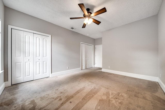 504 Macfie Ct, Madison, TN 37115 - unfurnished bedroom featuring two closets, baseboards, a textured ceiling, carpet flooring, and a ceiling fan