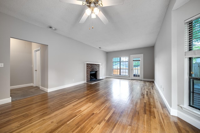 504 Macfie Ct, Madison, TN 37115 - unfurnished living room with wood finished floors, a textured ceiling, a fireplace, a ceiling fan, and baseboards