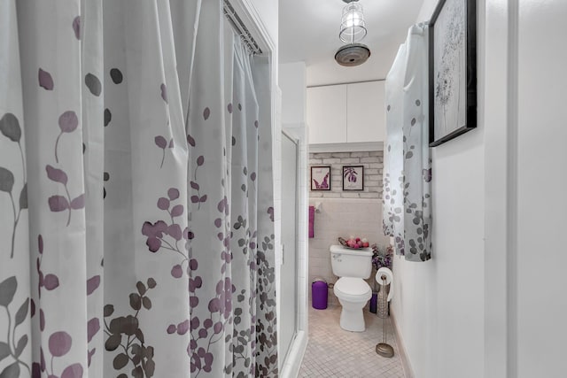3109 Stokers Ln, Nashville, TN 37218 - bathroom featuring tile patterned floors, toilet, tile walls, and a stall shower