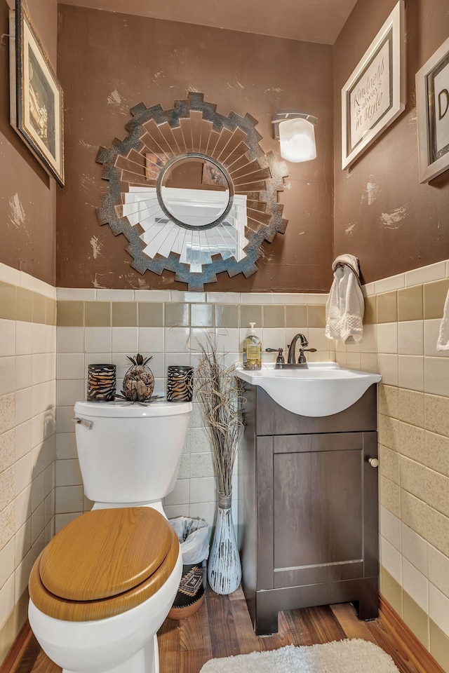 3109 Stokers Ln, Nashville, TN 37218 - half bathroom with tile walls, vanity, wood finished floors, toilet, and wainscoting