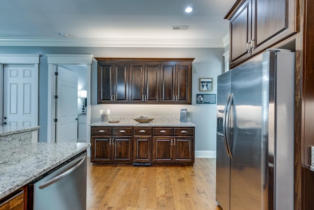 105 Andrews Dr, Loretto, TN 38469 - kitchen with stainless steel appliances, dark brown cabinets, light wood finished floors, light stone counters, and crown molding