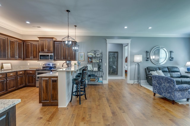 105 Andrews Dr, Loretto, TN 38469 - kitchen with appliances with stainless steel finishes, a breakfast bar area, open floor plan, dark brown cabinetry, and light stone countertops