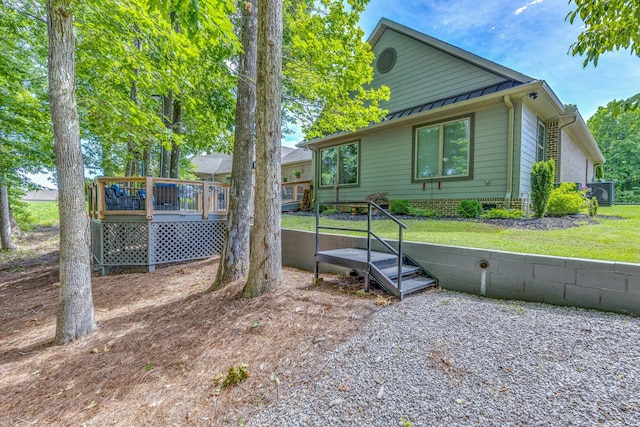 105 Andrews Dr, Loretto, TN 38469 - view of side of home with a deck, a standing seam roof, metal roof, a lawn, and central AC unit