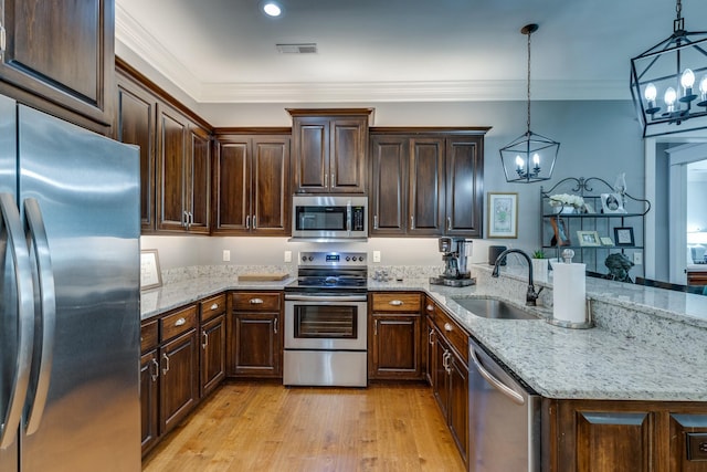 105 Andrews Dr, Loretto, TN 38469 - kitchen featuring stainless steel appliances, a sink, a chandelier, a peninsula, and light wood-style floors