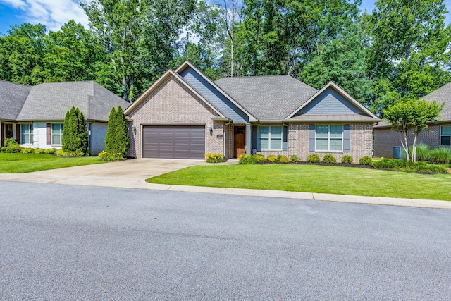 105 Andrews Dr, Loretto, TN 38469 - view of front of home featuring a garage, driveway, brick siding, and a front lawn