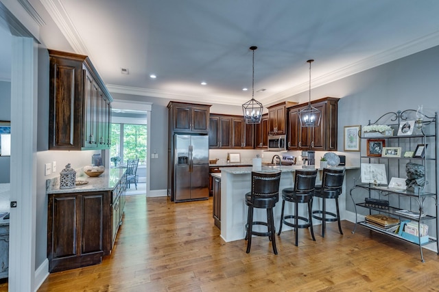 105 Andrews Dr, Loretto, TN 38469 - kitchen with stainless steel appliances, a peninsula, dark brown cabinetry, light wood finished floors, and crown molding