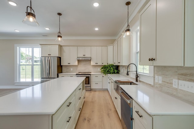 110 4th Ave S, Loretto, TN 38469 - kitchen featuring stainless steel appliances, a sink, a kitchen island, light wood-type flooring, and crown molding