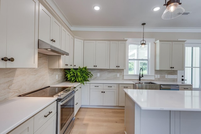 110 4th Ave S, Loretto, TN 38469 - kitchen featuring appliances with stainless steel finishes, under cabinet range hood, a sink, light countertops, and hanging light fixtures