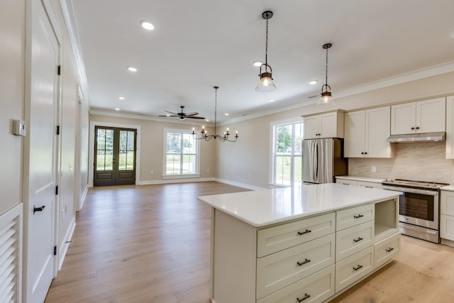 110 4th Ave S, Loretto, TN 38469 - kitchen with appliances with stainless steel finishes, under cabinet range hood, ornamental molding, plenty of natural light, and light wood-style flooring
