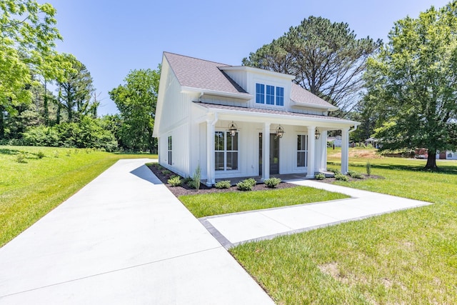 110 4th Ave S, Loretto, TN 38469 - modern farmhouse with board and batten siding, a porch, a front lawn, driveway, and a shingled roof