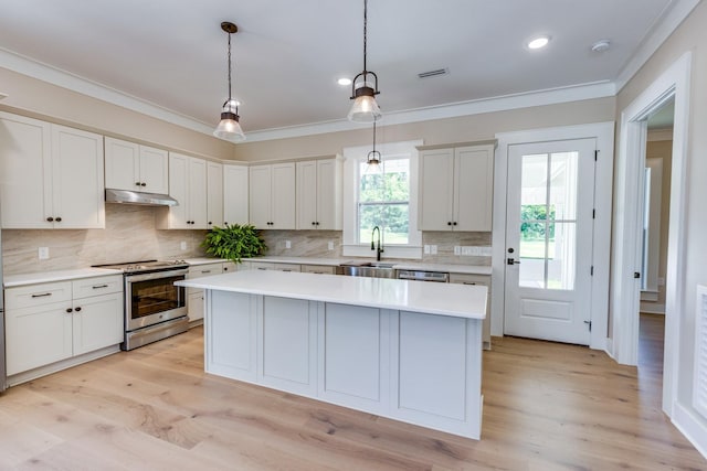 110 4th Ave S, Loretto, TN 38469 - kitchen featuring stainless steel appliances, under cabinet range hood, crown molding, a kitchen island, and light countertops