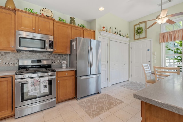 565 Scout Dr, Mount Juliet, TN 37122 - kitchen with stainless steel appliances, brown cabinetry, tasteful backsplash, ceiling fan, and light tile patterned floors