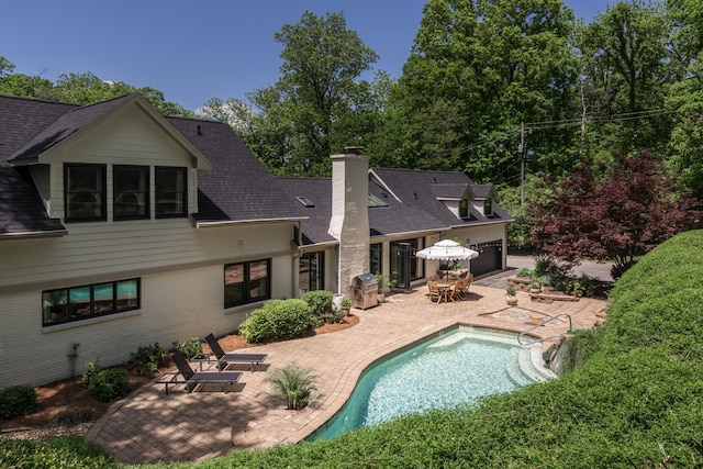 2300 Chickering Ln, Nashville, TN 37215 - back of property featuring a patio, roof with shingles, a chimney, a garage, and an outdoor pool