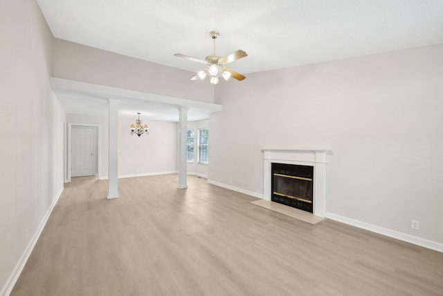 804 Beazer Ln, Antioch, TN 37013 - unfurnished living room with a fireplace with flush hearth, light wood finished floors, ceiling fan, ornate columns, and a chandelier
