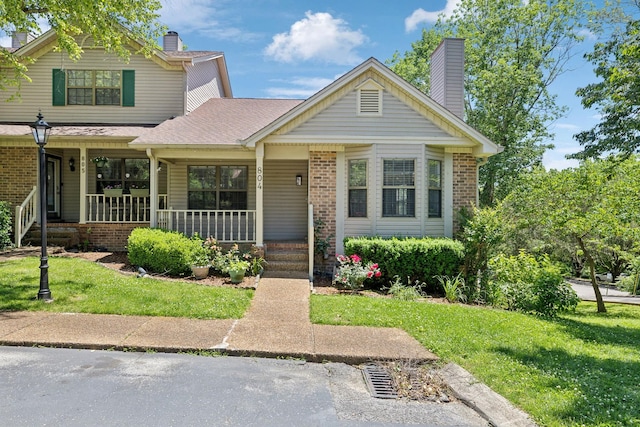 804 Beazer Ln, Antioch, TN 37013 - view of front of house featuring a chimney, covered porch, a front yard, brick siding, and roof with shingles