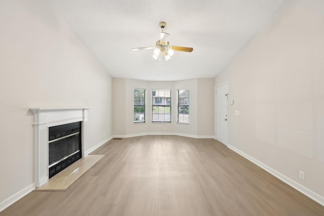 804 Beazer Ln, Antioch, TN 37013 - unfurnished living room featuring ceiling fan, wood finished floors, a glass covered fireplace, and baseboards