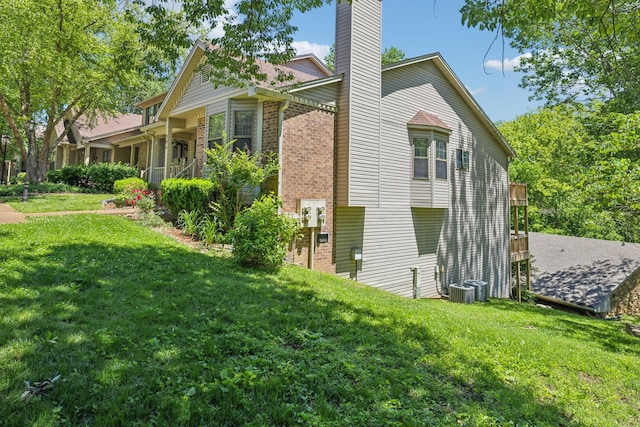 804 Beazer Ln, Antioch, TN 37013 - view of property exterior featuring brick siding, a chimney, a yard, and central AC