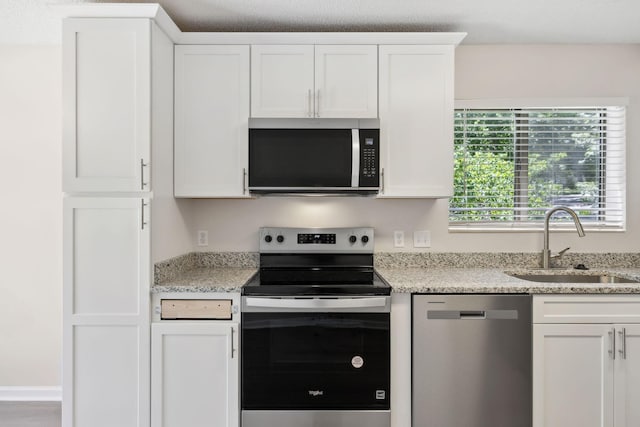 804 Beazer Ln, Antioch, TN 37013 - kitchen with stainless steel appliances, a sink, white cabinetry, and light stone counters