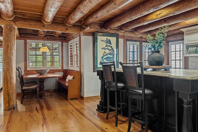 562 Rocky Ridge Rd E, Rock Island, TN 38581 - dining space with light wood-style flooring, wooden ceiling with exposed beams, plenty of natural light, baseboards, and rustic walls