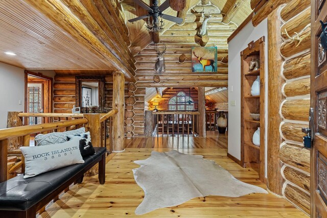 562 Rocky Ridge Rd E, Rock Island, TN 38581 - living area with log walls, an upstairs landing, light wood-style floors, a ceiling fan, and beam ceiling