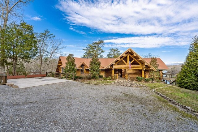 562 Rocky Ridge Rd E, Rock Island, TN 38581 - view of front of home with log exterior, gravel driveway, and metal roof